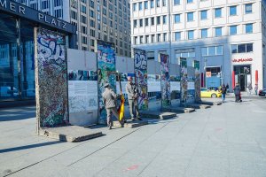 Versetzte Segmente der Mauer der 4. Generation ("Grenzmauer 75") am Potsdamer Platz als Ausstellungsinstallation und Kulisse mit kostümierten Schauspielern; Aufnahme 2015