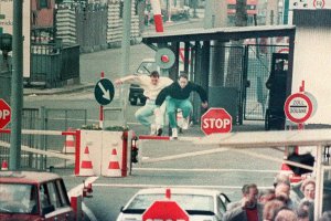 Zwei junge Ost-Berliner überspringen am 8. April 1989 den Schlagbaum am Grenzübergang Chausseestraße in Berlin-Mitte.