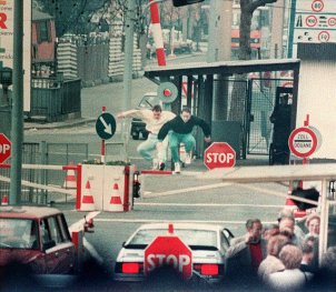 Zwei junge Ost-Berliner überspringen am 8. April 1989 den Schlagbaum am Grenzübergang Chausseestraße in Berlin-Mitte.