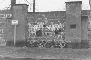 West-Berliner, die den St.-Hedwigs-Friedhof an der Liesenstraße nicht mehr betreten dürfen, legen ihren Grabschmuck am zugemauerten Friedhofseingang ab, 26. November 1961.