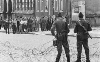 Stacheldrahtsperre in der Bernauer Straße: Volkspolizisten halten Ost-Berliner in Schach; Aufnahme 13. August 1961