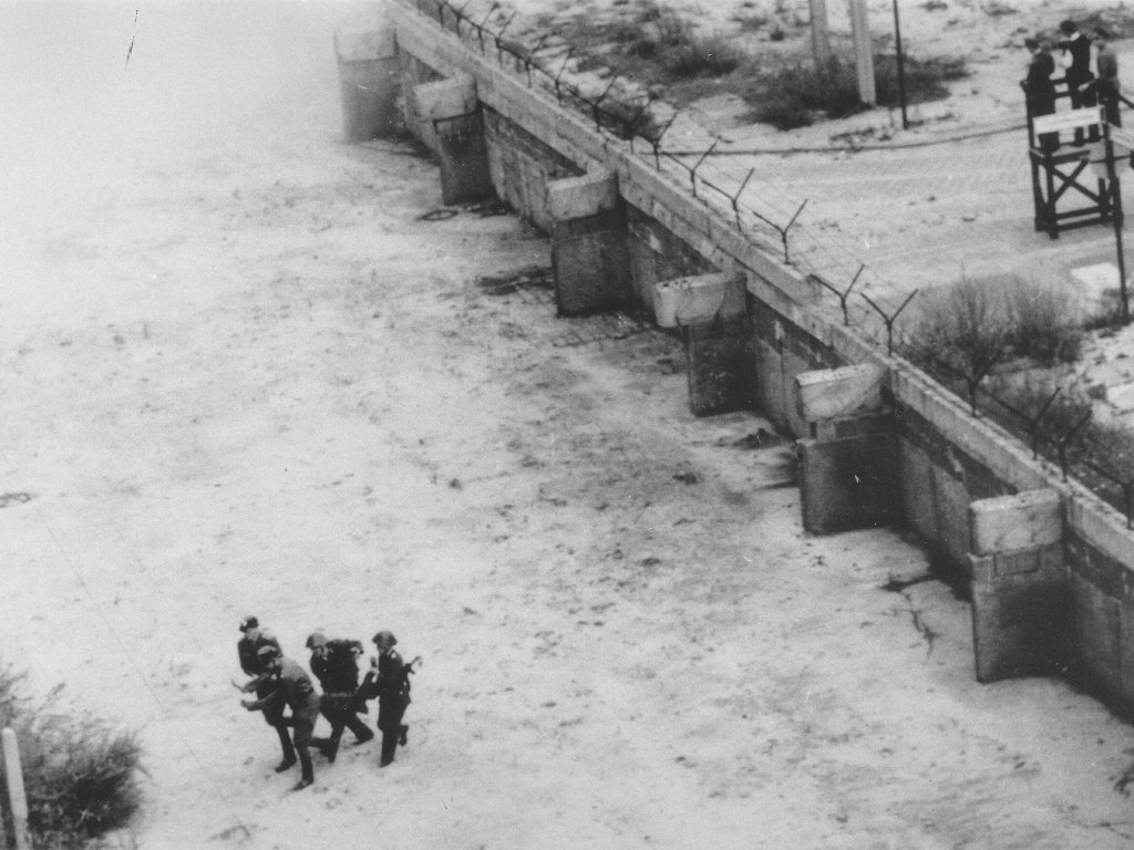 Peter Fechter, erschossen an der Berliner Mauer: Bergung des Sterbenden durch DDR-Grenzposten in der Zimmerstraße nahe dem Grenzübergang Checkpoint Charlie (IV), 17. August 1962 Peter Fechter, erschossen an der Berliner Mauer: Bergung des Sterbenden durch DDR-Grenzposten in der Zimmerstraße nahe dem Grenzübergang Checkpoint Charlie (IV), 17. August 1962