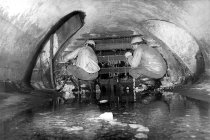 Abbau der Absperrgitter nach Mauerfall: Hunderte Menschen fliehen durch die unterirdische Kanalisation, bis der Einbau von Gittern neue Wege erzwingt; Aufnahme 1990