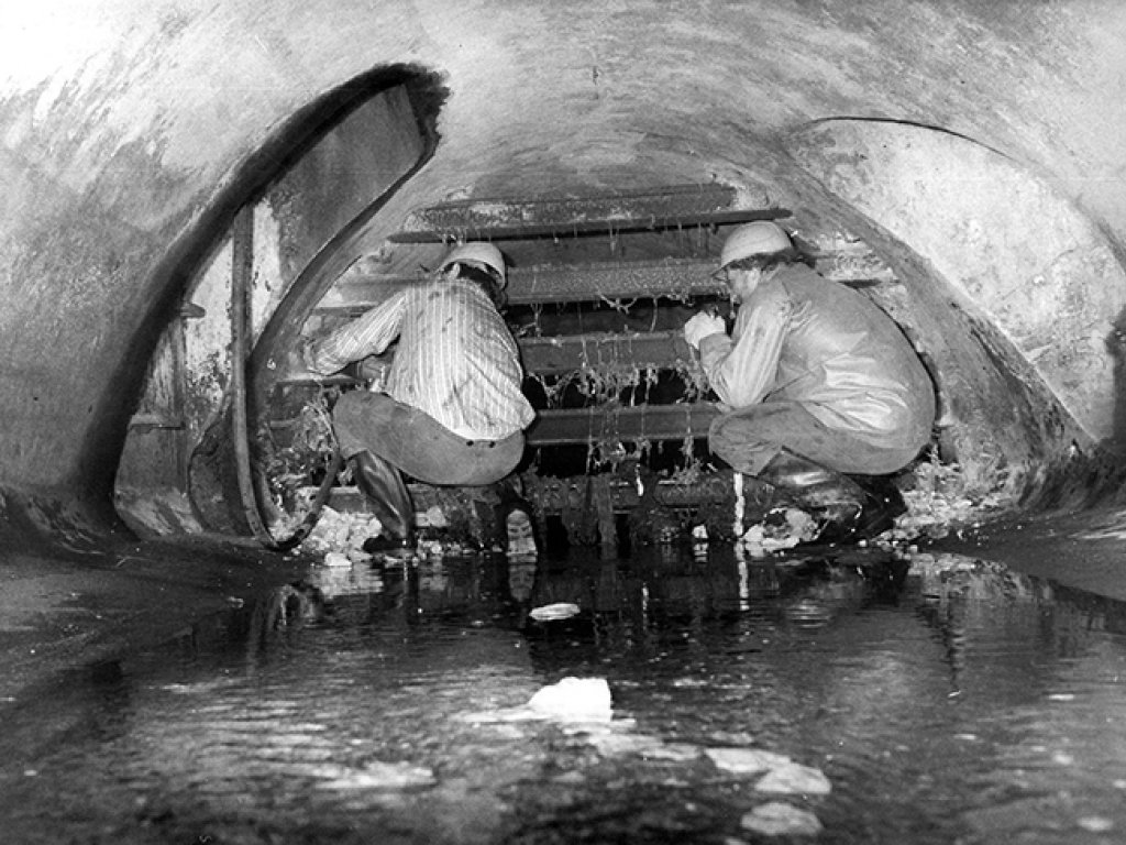 Abbau der Absperrgitter nach Mauerfall: Hunderte Menschen fliehen durch die unterirdische Kanalisation, bis der Einbau von Gittern neue Wege erzwingt; Aufnahme 1990
