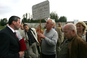 2006: Bei einer Gedenkveranstaltung im Grenzmuseum in H&ouml;tensleben zum 45. Jahrestag des Mauerbaus h&auml;lt ein ehemaliger Grenzsoldat ein Schild, auf dem zu lesen ist: &bdquo;Ex-wehrpflichtiger Grenzer 1963-64 Sorge-Harz. Befehl: &sbquo;Jeder Grenzdurchbruch ist zu verhindern, von der Waffe ist r&uuml;cksichtslos Gebrauch zu machen.&lsquo; Habe, h&auml;tte nie geschossen.&ldquo;.