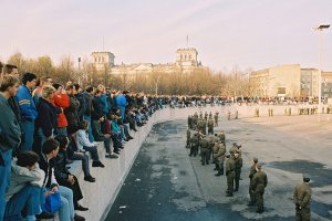 Am  Brandenburger Tor: Demonstranten auf der Panzermauer, Grenzsoldaten sichern den Raum.