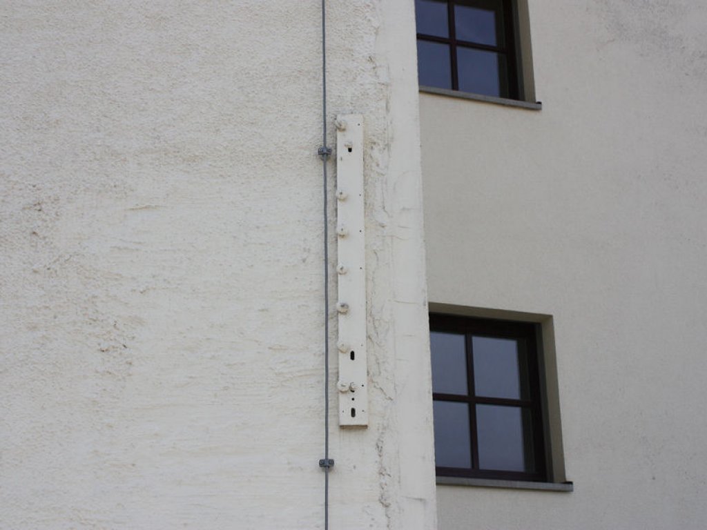 Übermaltes Trägerteil mit Isolatoren: Reste des Grenzsignalzaunes an einem Haus in der Kommandantenstraße in Berlin-Mitte; Aufnahme 2016