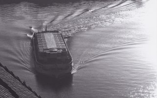Das Schiff ist aus der Vogelperspektive aufgenommen. Die Bewegungen auf der Wasseroberfläche lassen erkennen, dass es eine scharfe Kurve genommen hat.