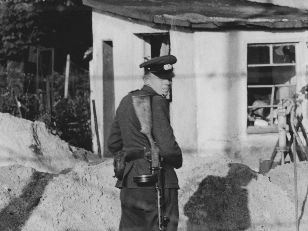 Grenzpolizist an der Berliner Sektorengrenze nachdem er Zigaretten und Schokolade, die ihm West-Berliner zugeworfen haben, zertreten hat, 24. September 1961. Grenzpolizist an der Berliner Sektorengrenze nachdem er Zigaretten und Schokolade, die ihm West-Berliner zugeworfen haben, zertreten hat, 24. September 1961.