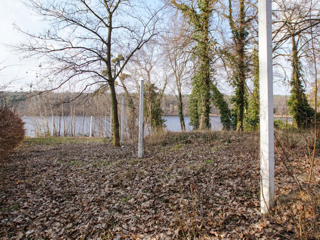 Markierung des Mauerverlaufs mit Holzpfosten in der Stubenrauchstraße am Griebnitzsee in Potsdam-Babelsberg (Installation von 2009); Aufnahme 2015