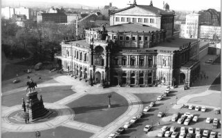 Blick auf die Dresdener Semperoper aus der Vogelperspektive. Links im Vordergrund das König-Johann-Denkmal, rechts ein Parkplatz.