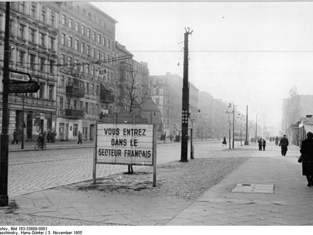 Blick in die Bernauer Straße, in der die Sektorengrenze zwischen Ost- und West-Berlin mit der Häuserwand auf der linken Straßenseite verläuft; Aufnahme 5. November 1955 Blick in die Bernauer Straße, in der die Sektorengrenze zwischen Ost- und West-Berlin mit der Häuserwand auf der linken Straßenseite verläuft; Aufnahme 5. November 1955