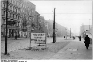 Blick in die Bernauer Straße, in der die Sektorengrenze zwischen Ost- und West-Berlin mit der Häuserwand auf der linken Straßenseite verläuft; Aufnahme 5. November 1955
