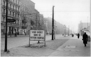 Blick in die Bernauer Straße, in der die Sektorengrenze zwischen Ost- und West-Berlin mit der Häuserwand auf der linken Straßenseite verläuft; Aufnahme 5. November 1955