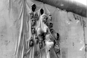 Ein Mauerabschnitt ist mit einem Stofftuch bedeckt. Aus den Falten des Tuches ragen 23 Gipsk&ouml;pfe.