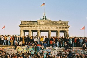 Menschenmengen drängen sich auf und vor der Mauer vor dem Brandenburger Tor.