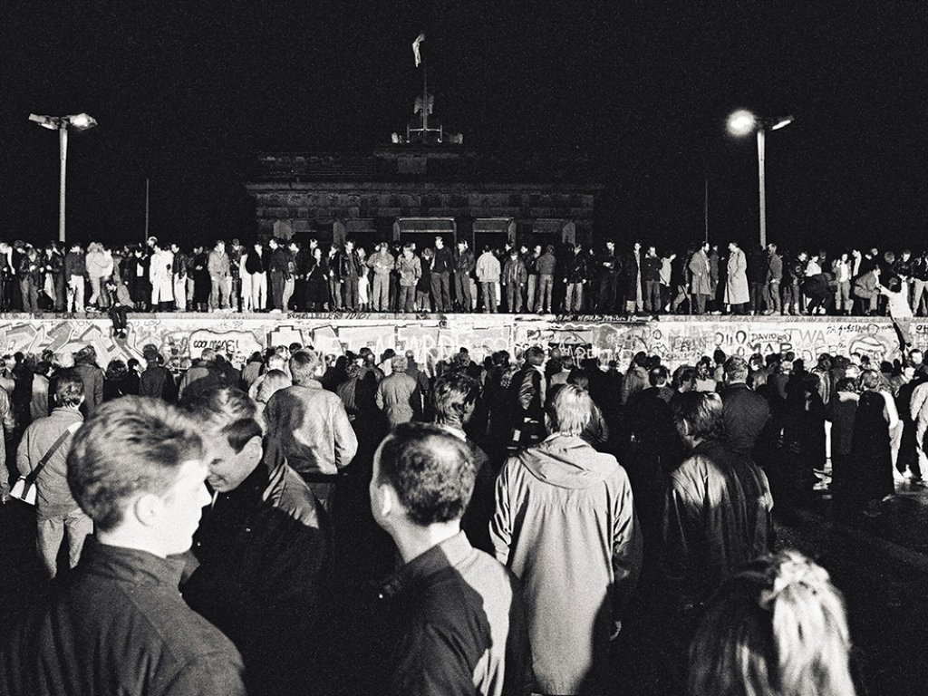 West- und Ost-Berliner auf der Mauerkrone am Brandenburger Tor
