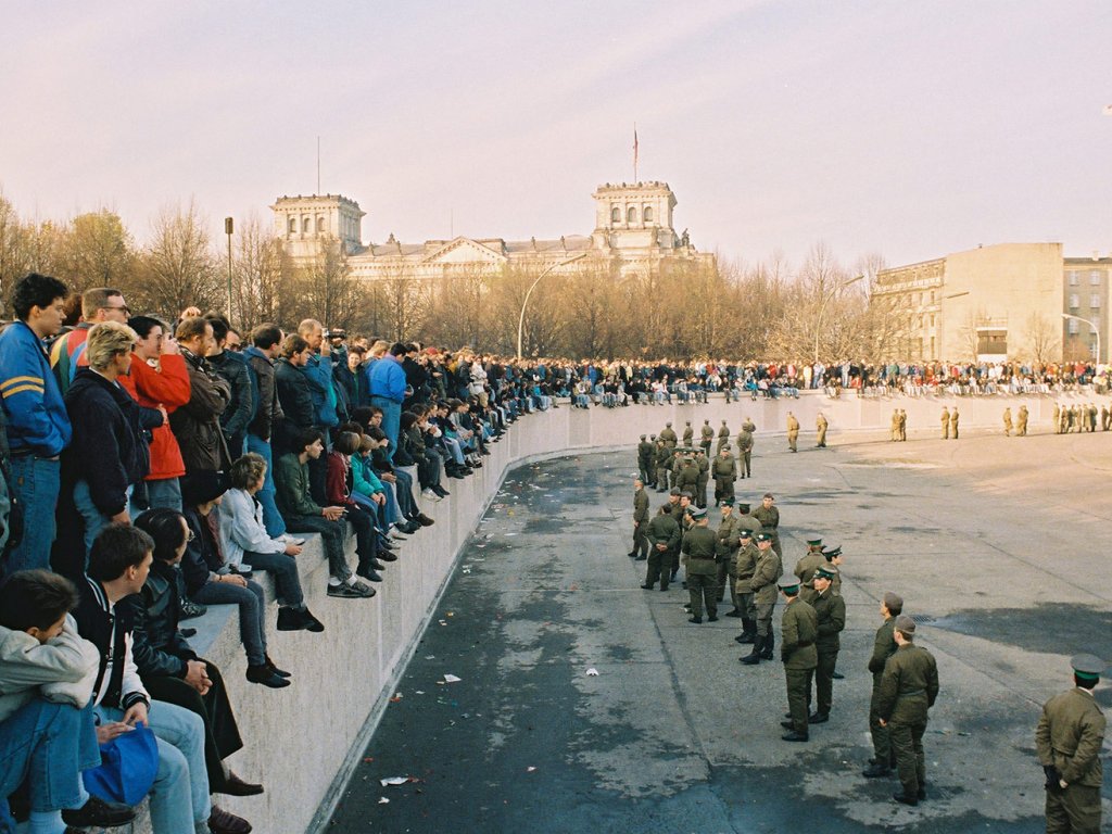 At the Brandenburg Gate: Demonstrators on the top of the Wall, border soldiers secure the area.
