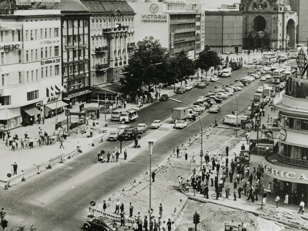 1962: Die Anteilnahme in der Bevölkerung ist immer noch groß, Szene am Kurfürstendamm: mit einem Verkehrsstopp und dreiminütigem Schweigen gedenkt West-Berlin am 13. August um 12.00 Uhr des Mauerbaus, darauf folgt ein Hupkonzert als Protestkundgebung.