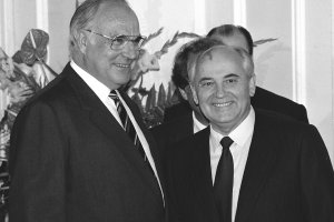 Helmut Kohl steht links neben Michail Gorbatschow, beide lächeln.