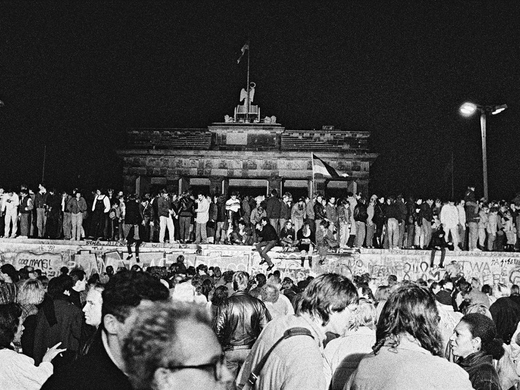 West- und Ost-Berliner auf der Mauerkrone am Brandenburger Tor