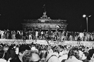 West- und Ost-Berliner auf der Mauerkrone am Brandenburger Tor