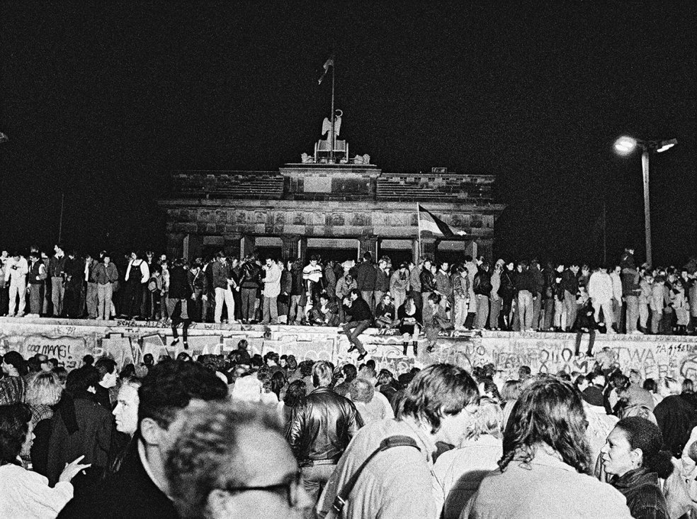 West- und Ost-Berliner auf der Mauerkrone am Brandenburger Tor