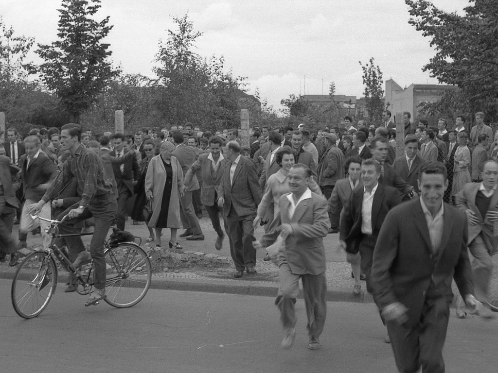 Einige nutzen die Möglichkeit zur Flucht und laufen auf die anderen Straßenseite nach West-Berlin; Aufnahme 13. August 1961