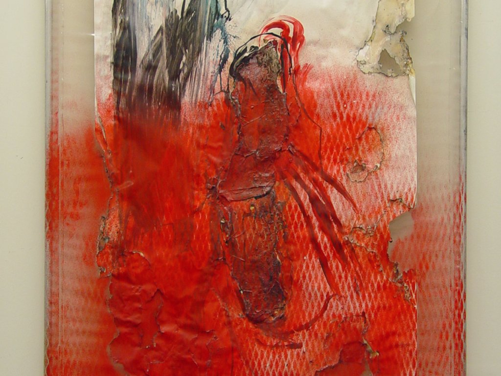 Nahaufnahme eines Gemäldes. Das Bild besteht aus einer auf Rohrrahmen aufgespannten Plastikfolie. Weißes Papier ist darauf angebracht, das teilweise angebrannt und mit Farbe bemalt ist. In roter Farbe ist im unteren Bildteil der Abdruck der Streckmetallzaunes zu erkennen.