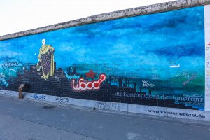 Die "East Side Gallery" als längste denkmalgeschützte Leinwand der Welt, hier exemplarisch das Werk "Die Beständigkeit der Ignoranz" von Karsten Wenzel; Aufnahme 2015