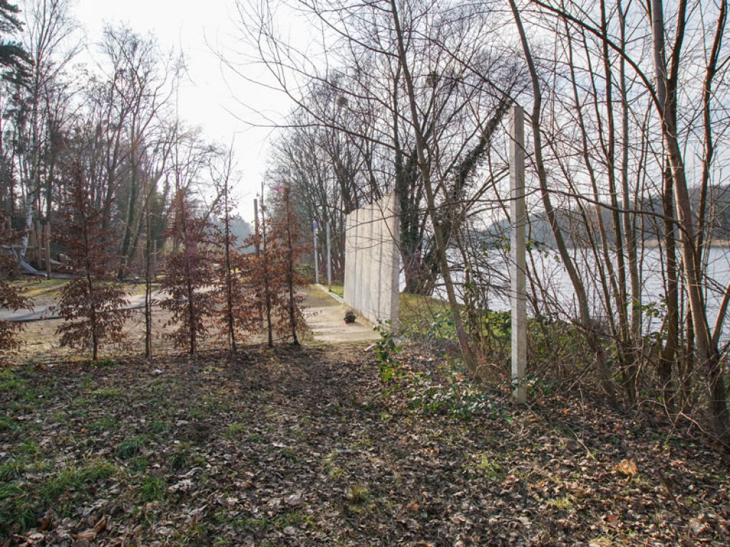 Original-Mauersegmente der DDR-Grenzanlagen am Griebnitzsee in Potsdam-Babelsberg, integriert in eine Inszenierung des Mauerverlaufs mit Holzpfosten; Aufnahme 2015