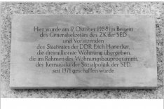 Steinplakette mit der Inschrift: Hier wurde am 12. Oktober 1988 im Beisein des Generalsekretärs des ZK der SED und Vorsitzenden des Staatsrates der DDR, Erich Honecker, die dreimillionste Wohnung übergeben, die im Rahmen des Wohnungsbauprogramms, des Kernstücks der Sozialpolitik der SED, seit 1971 geschaffen wurde.