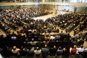1986: Gedenkveranstaltung zum 25. Jahrestag des Mauerbaus im Reichstagsgeb&auml;ude in West-Berlin. Trotz der Ann&auml;herung beider deutscher Staaten, sagt Bundeskanzler Helmut Kohl in seiner Rede: &bdquo;Wir werden und d&uuml;rfen uns nicht an dieses Monument der Unmenschlichkeit gew&ouml;hnen &hellip; Solange es Mauer, Stacheldraht und Schie&szlig;befehl gibt, kann von Normalit&auml;t in Deutschland keine Rede sein.&ldquo;.