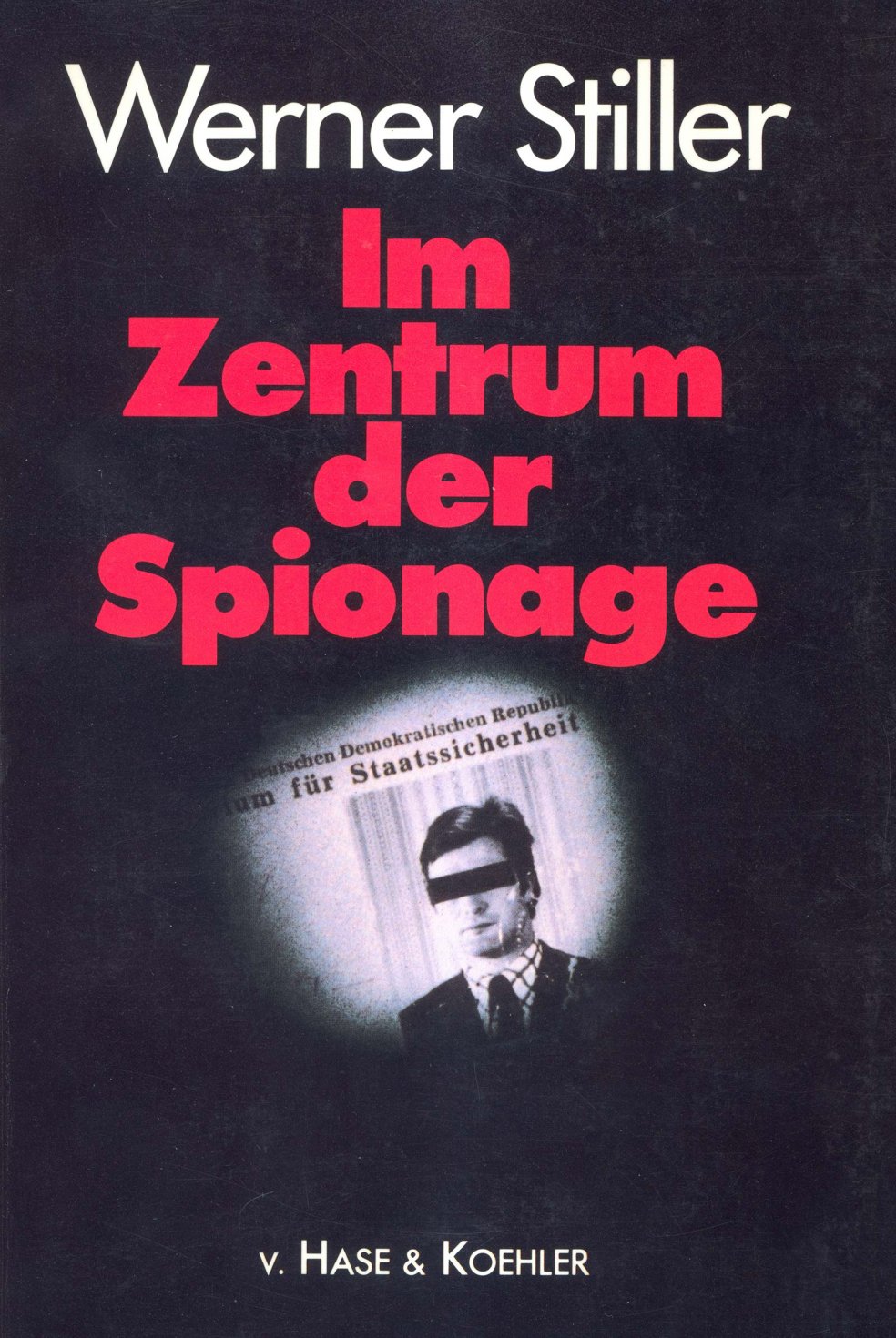 Das Buchcover ist schwarz, der Titel &bdquo;Im Zentrum der Spionage&ldquo; rot. Unterhalb des Titels sieht man wie durch einen T&uuml;rspion auf ein Portr&auml;t von Werner Stiller mit schwarzem Balken &uuml;ber den Augen. &Uuml;ber dem Foto ist zu lesen: &bdquo;Deutschen Demokratischen Republik&ldquo; und angeschnitten: &bdquo;Ministerium f&uuml;r Staatssicherheit&ldquo;.