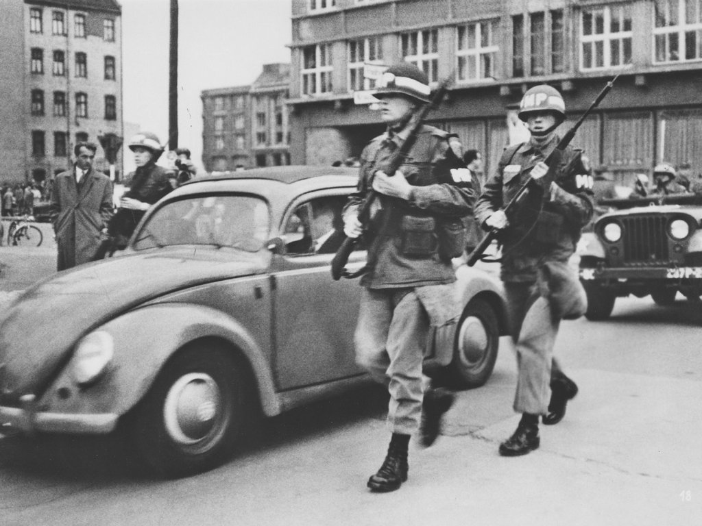US-Soldaten eskortieren ein Zivilfahrzeug über den Grenzübergang am Checkpoint Charlie, Oktober 1961.