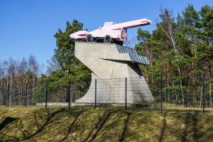 „Panzerdenkmal“: Seit 1992 ziert ein rosa lackierter Schneelader– ein Kunstwerk von Eckhart Haisch – den Ehrenmalsockel am DDR-Grenzübergang Drewitz, auf dem bis dahin ein sowjetischer T34-Panzer das Kanonenrohr auf West-Berlin richtete (2); Aufnahme 2015