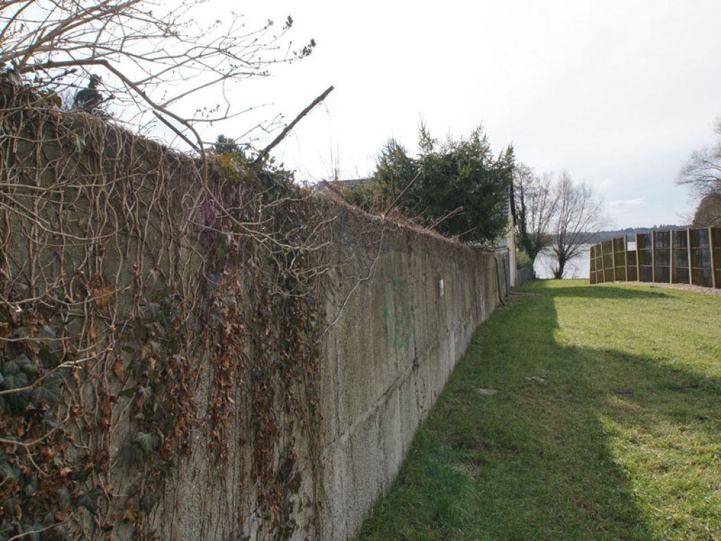 Berliner Mauer der 1. Generation von 1961/62 aus Betonblöcken und Hohlblocksteinen am Groß Glienicker See, rechts daneben der Streckmetallgitterzaun der 1980er Jahre; Aufnahme 2015