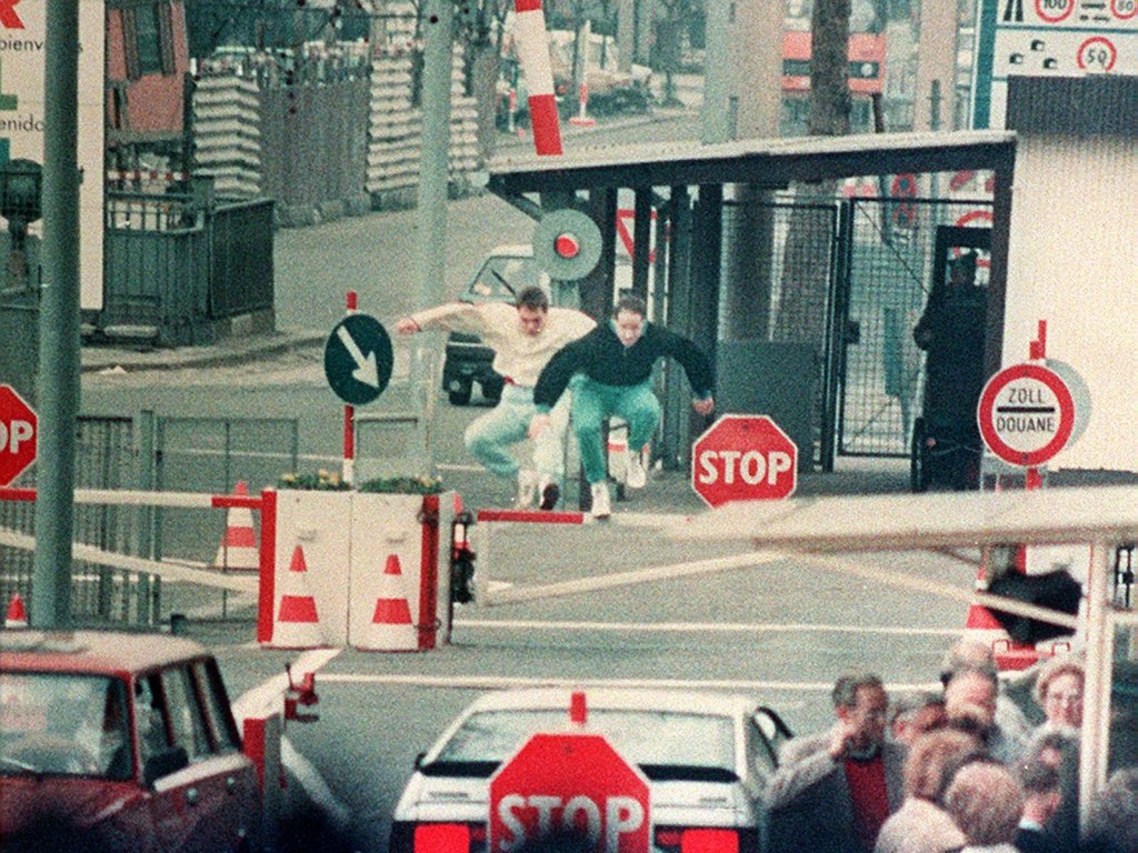 East Berliners jump over the barrier