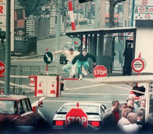 East Berliners jump over the barrier