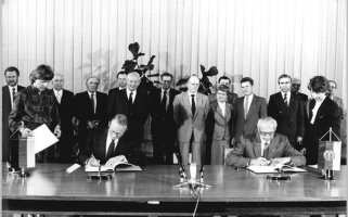 Dr. Hans Otto Bräutigam, Leiter der Ständigen Vertretung der Bundesrepublik in der DDR, und Kurt Nier, Stellvertreter des DDR-Ministers für Auswärtige Angelegenheiten (v. l. n. r.) unterschreiben ein Kulturabkommen zwischen der Bundesrepublik und der DDR in Ost-Berlin; Aufnahme 6. Mai 1986