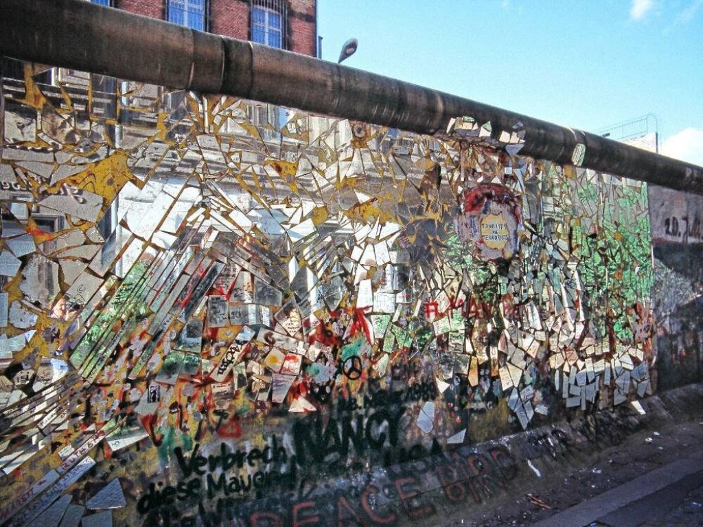 Ein Stück der Berliner Mauer ist über und über mit kleinen Spiegelsplittern beklebt.