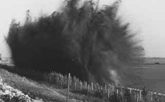 Das Landschaftsbild ist dominiert von einer riesigen, schwarzen Explosionswolke.