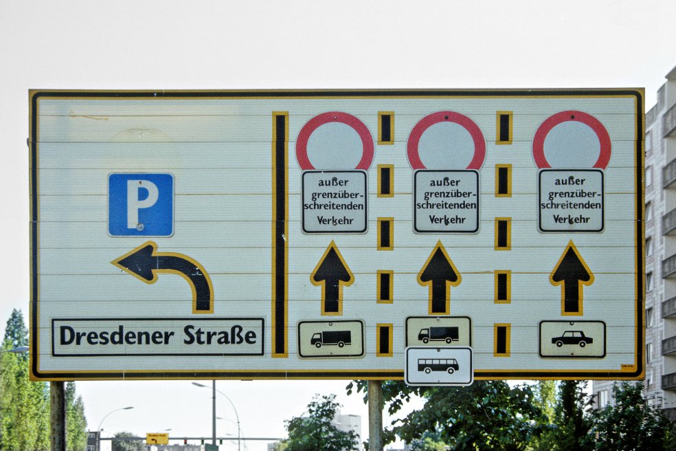Hinweisschild zur Verkehrsführung des grenzüberschreitenden Verkehrs am Grenzübergang Heinrich-Heine-Straße zwischen den Bezirken Mitte (Ost-Berlin) und Kreuzberg (West-Berlin); Aufnahme 10. Mai 1990