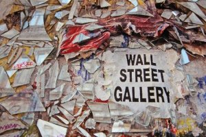 Nahaufnahme von der mit Spiegelsplittern beklebten Mauer. Gro&szlig; im Bild ist die Aufschrift zu lesen: Wall Street Gallery.