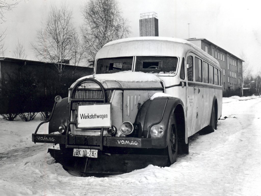 Der alte Bus steht im Schnee. An der Fahrzeugfront hängt ein Schild mit der Aufschrift Werkstattwagen. Durch die Frontscheibe sind die schützenden Platten zu erkennen, die nur über kleine Sichtlöcher verfügen.