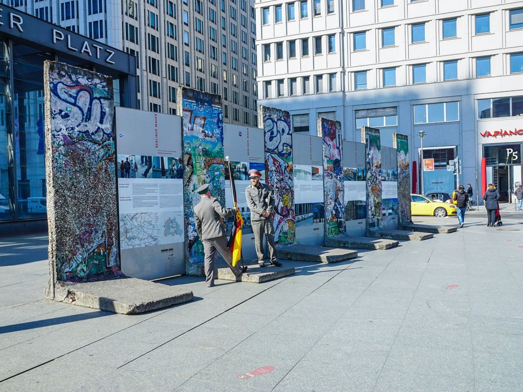 Versetzte Segmente der Mauer der 4. Generation ("Grenzmauer 75") am Potsdamer Platz als Ausstellungsinstallation und Kulisse mit kostümierten Schauspielern; Aufnahme 2015