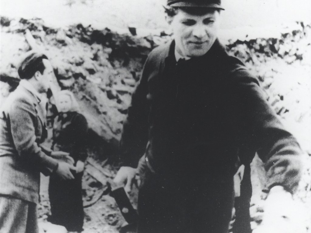 Erich Honecker – hier bei Enttrümmerungsarbeiten Anfang der 50-er Jahre – wird im Mai 1971 SED-Generalsekretär.  Der junge Erich Honecker steht zentral im Bild, in der rechten Hand hält er einen Hammer. Im Bildhintergrund ist ein mehrere Meter hoher Trümmerberg zu sehen, davor stehen ein Mann und eine Frau.