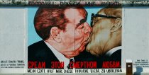 The picture shows the painting of the kissing politicians on the wall. The title of the artwork is in Russian and in German.