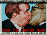 The picture shows the painting of the kissing politicians on the wall. The title of the artwork is in Russian and in German.