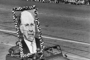 1966: Am f&uuml;nften Jahrestag des &bdquo;Antifaschistischen Schutzwalls&ldquo; wird die Mauer in der DDR offiziell mit Kampfgruppen-Paraden gefeiert. Der Zug f&uuml;hrt durch die Stra&szlig;e Unter den Linden, vorweg ein Wagen mit dem &uuml;berlebensgro&szlig;en Portr&auml;t des Staatsratsvorsitzenden Walter Ulbricht.